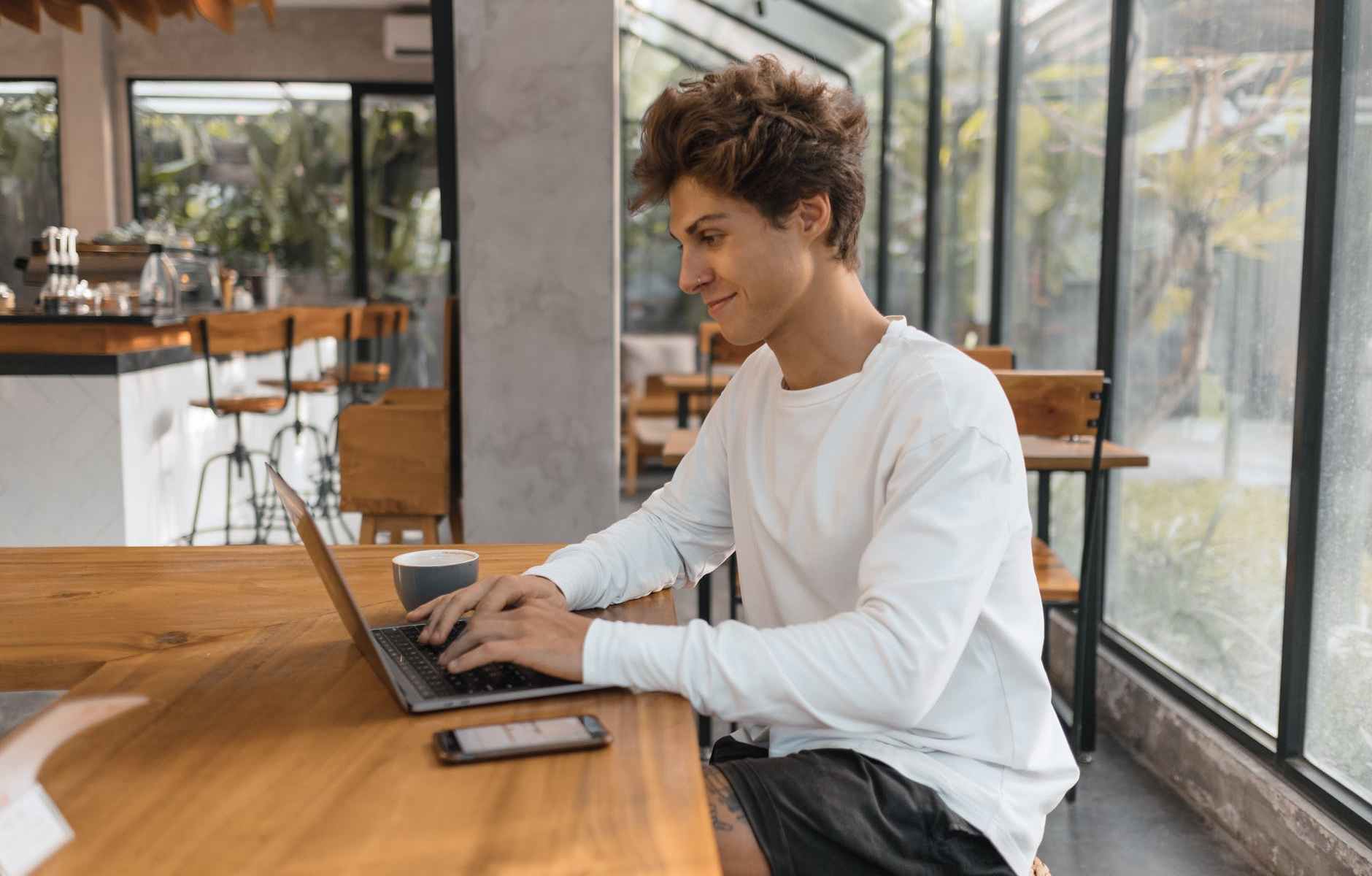 young man working on a laptop in a cafe